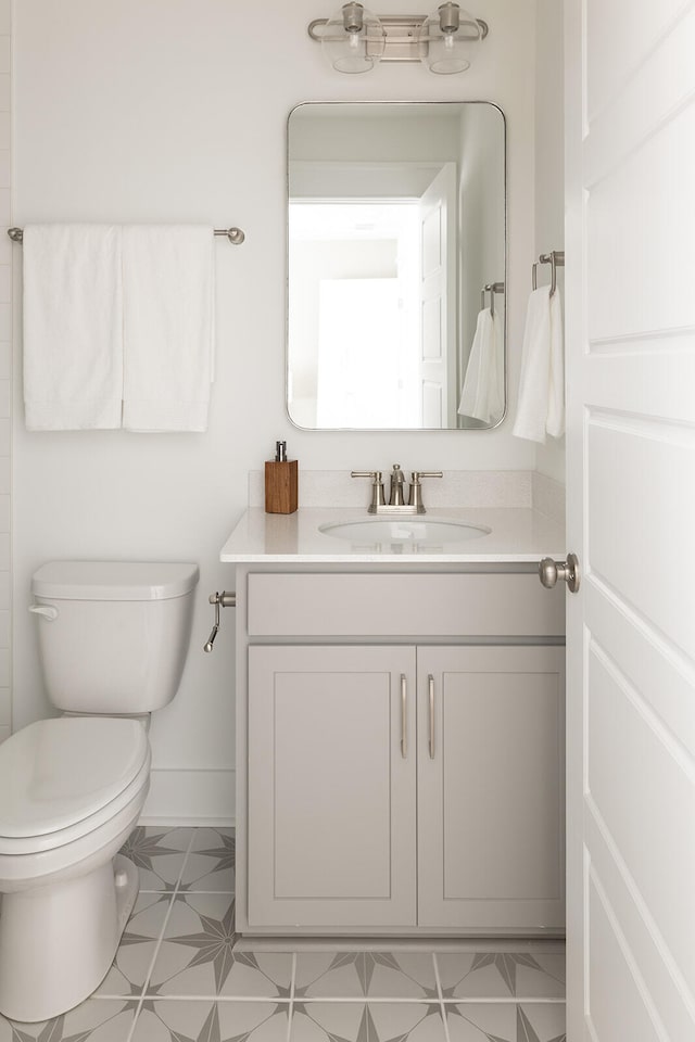 bathroom featuring tile patterned flooring, vanity, and toilet