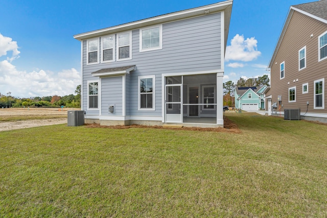 rear view of property with a sunroom, central AC unit, and a lawn