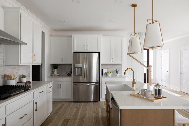 kitchen featuring an island with sink, white cabinetry, light hardwood / wood-style flooring, and stainless steel appliances