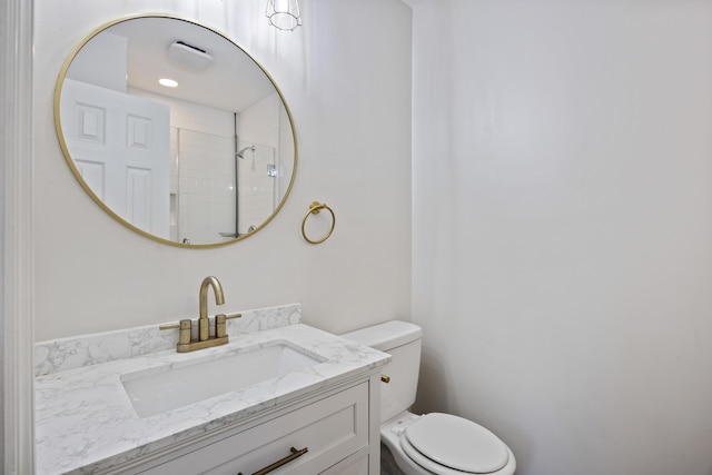 bathroom featuring toilet, a shower, and vanity