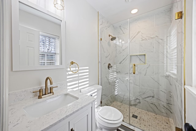 full bath with vanity, a shower stall, and toilet