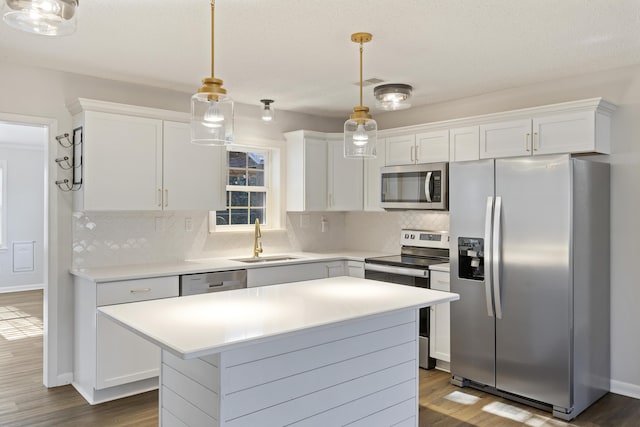 kitchen featuring dark wood finished floors, white cabinetry, stainless steel appliances, and a sink