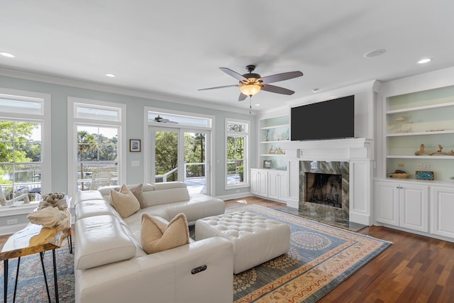 living room featuring crown molding, ceiling fan, a fireplace, recessed lighting, and wood finished floors