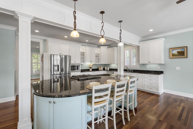 kitchen with stainless steel appliances, a center island, white cabinetry, and crown molding
