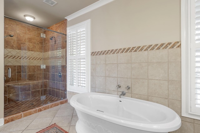 full bathroom featuring visible vents, tile walls, a freestanding tub, and a stall shower