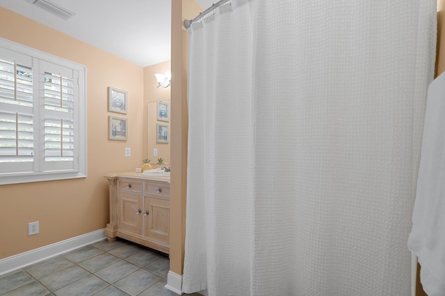 bathroom featuring tile patterned floors, vanity, baseboards, and visible vents