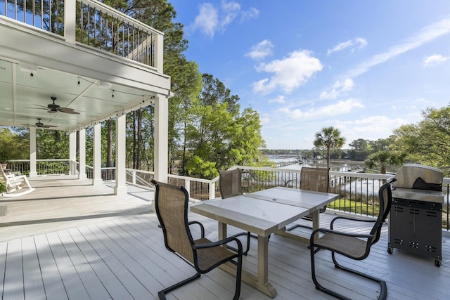 wooden terrace featuring area for grilling, outdoor dining space, ceiling fan, and a water view
