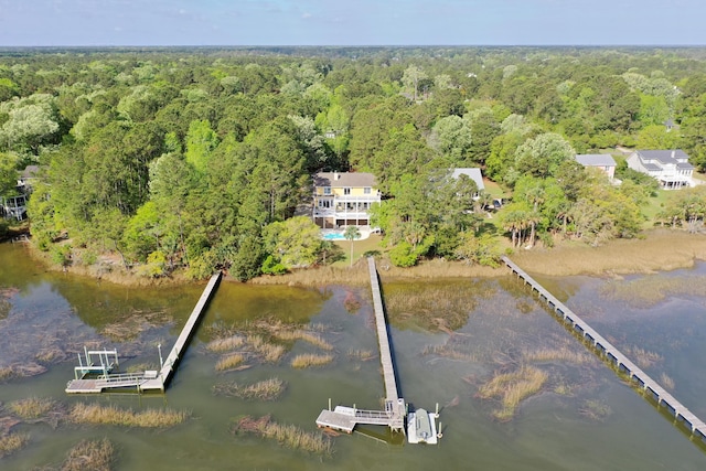 bird's eye view featuring a wooded view and a water view