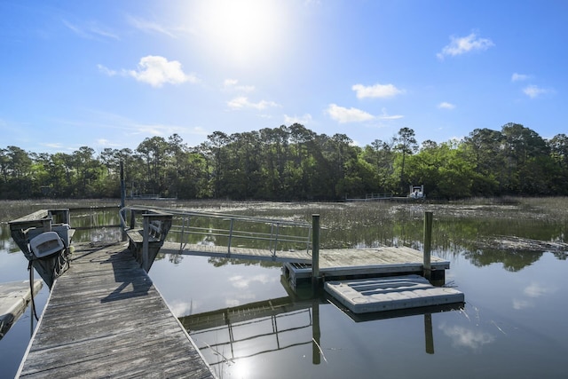 view of dock featuring a water view and a wooded view