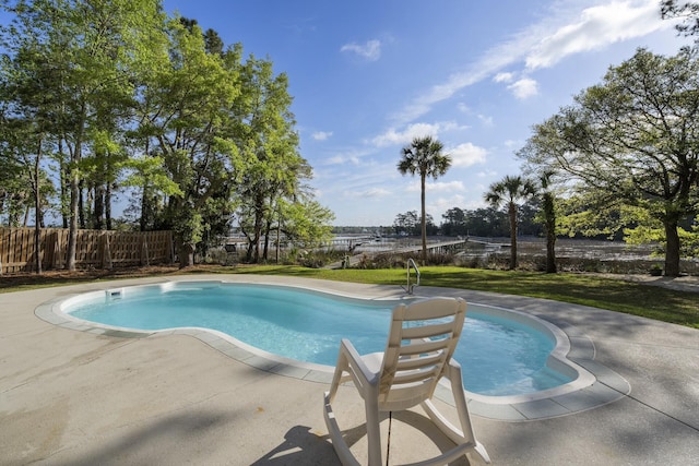 view of swimming pool featuring a yard, fence, a fenced in pool, and a patio