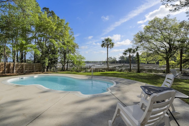 view of swimming pool featuring a patio, a fenced in pool, fence, and a lawn