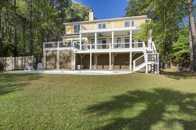 rear view of house featuring a yard, a ceiling fan, fence, stairway, and a patio