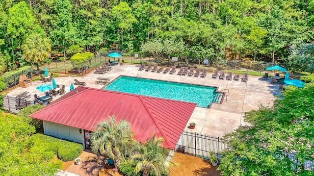 pool with a patio area and fence