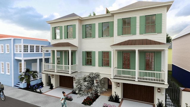 view of front facade featuring a standing seam roof, driveway, a balcony, and metal roof