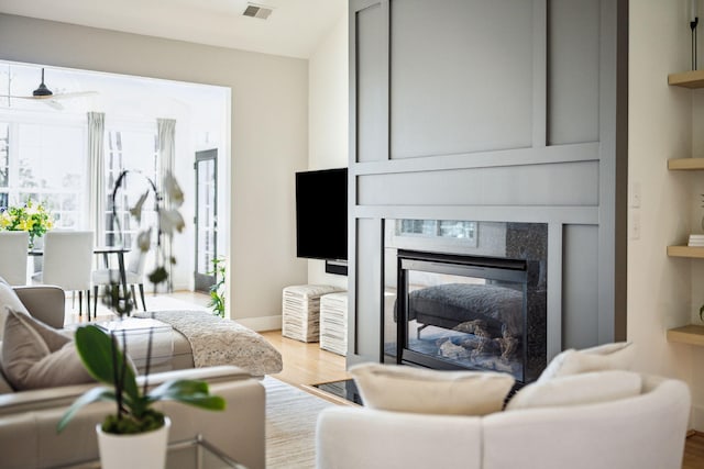 living room featuring wood-type flooring and built in features