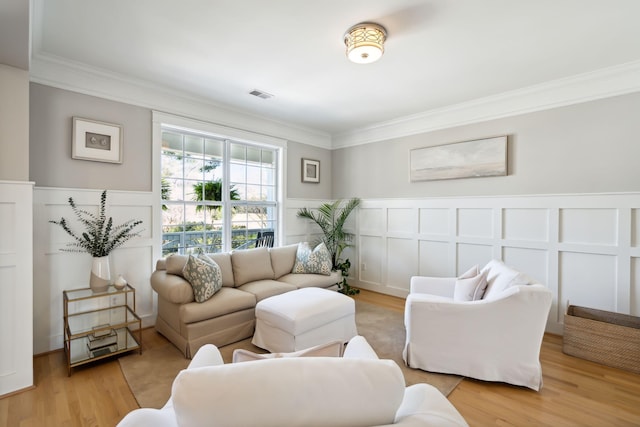 living room with crown molding and light hardwood / wood-style floors