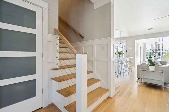 stairs featuring wood-type flooring and vaulted ceiling