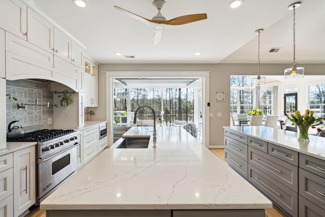 kitchen with hanging light fixtures, appliances with stainless steel finishes, a large island, and sink