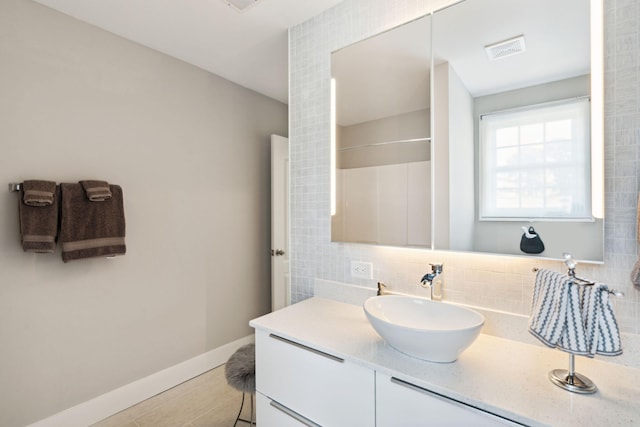 bathroom with tasteful backsplash, vanity, hardwood / wood-style floors, and walk in shower