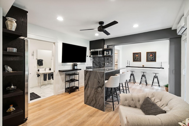 interior space with a wall mounted air conditioner, light hardwood / wood-style floors, and ceiling fan