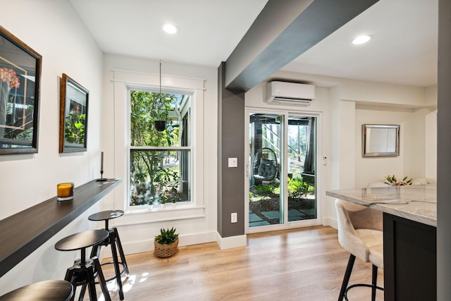 doorway to outside featuring a wall mounted AC and light wood-type flooring