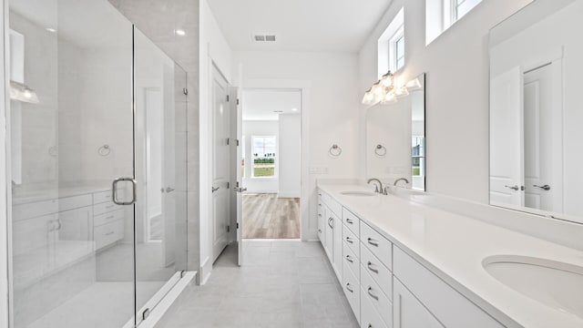 bathroom with double vanity and a stall shower
