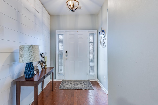 entryway featuring baseboards, an inviting chandelier, and hardwood / wood-style floors