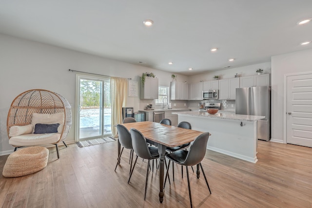 dining space featuring sink and light hardwood / wood-style flooring