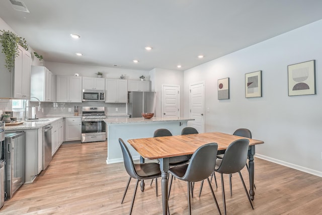 dining space featuring sink and light wood-type flooring