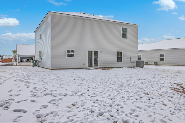 snow covered house featuring cooling unit