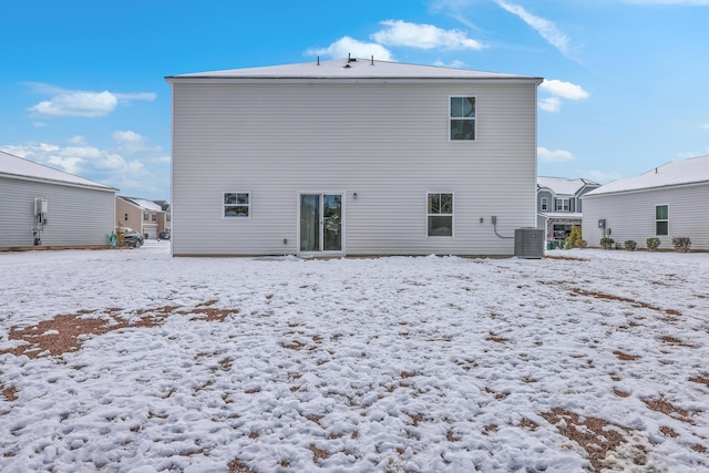 snow covered rear of property with central air condition unit