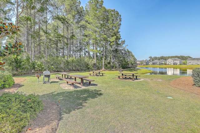 view of community featuring a water view and a yard