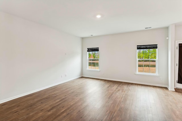 empty room with light hardwood / wood-style flooring and plenty of natural light