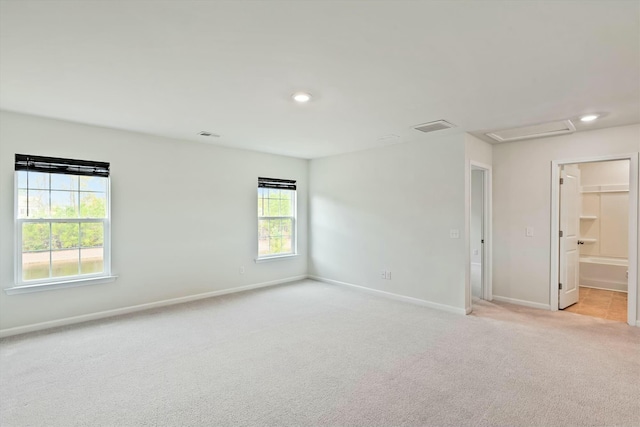 unfurnished room featuring light carpet and plenty of natural light