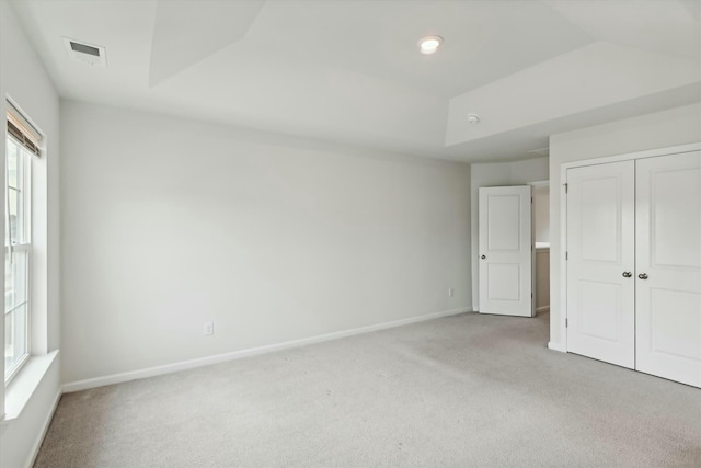 unfurnished bedroom featuring light carpet and a closet