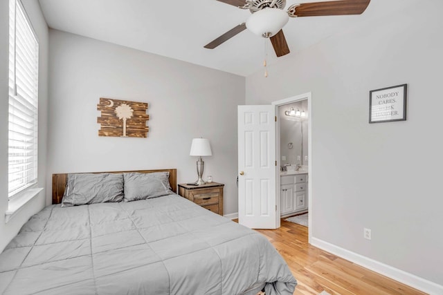 bedroom featuring hardwood / wood-style floors, ceiling fan, connected bathroom, and lofted ceiling