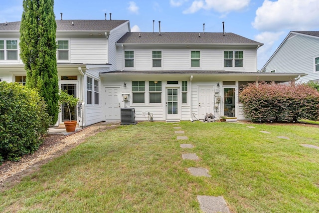 rear view of house featuring a lawn and central AC