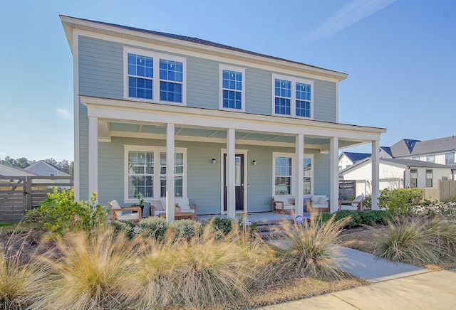 view of front of property with a porch and fence