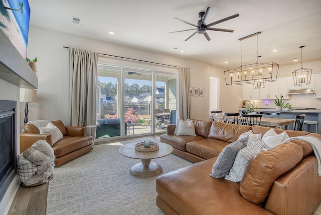 living room with wood finished floors, visible vents, recessed lighting, a fireplace, and ceiling fan