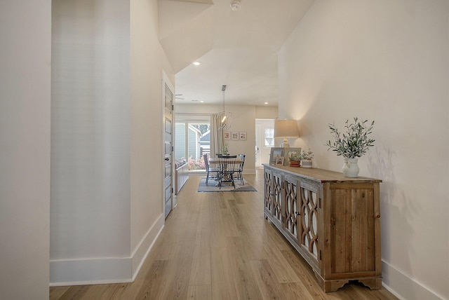 hallway with light wood finished floors, recessed lighting, and baseboards