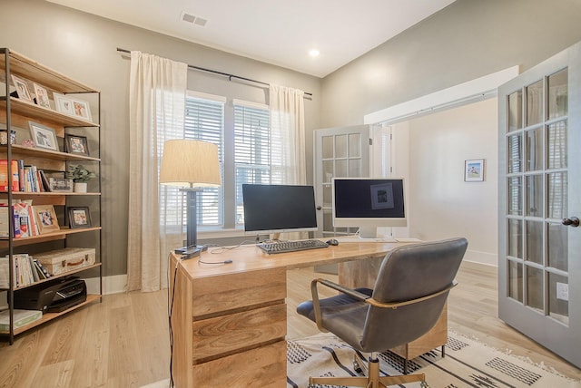 home office featuring light wood-type flooring, baseboards, visible vents, and french doors