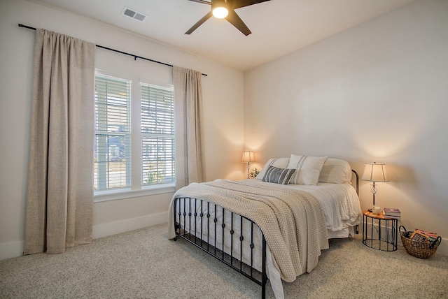 carpeted bedroom featuring visible vents, baseboards, and ceiling fan