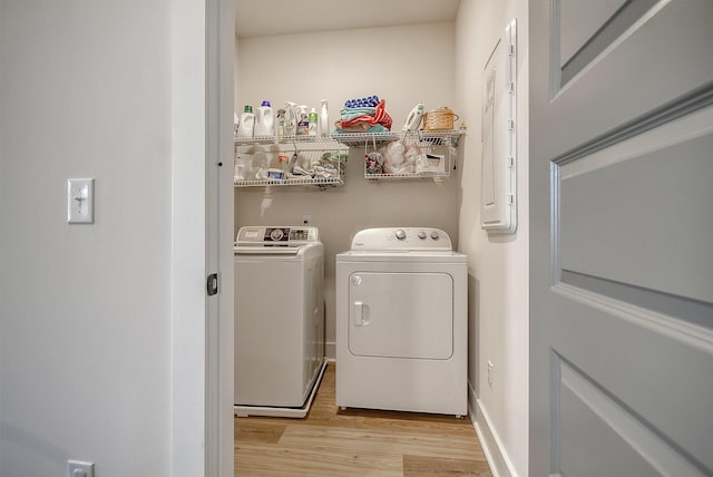 laundry room with laundry area, baseboards, light wood-style floors, and separate washer and dryer