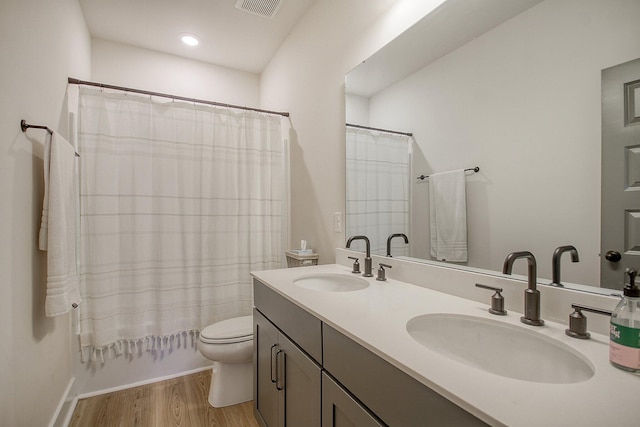 bathroom with a sink, visible vents, toilet, and wood finished floors