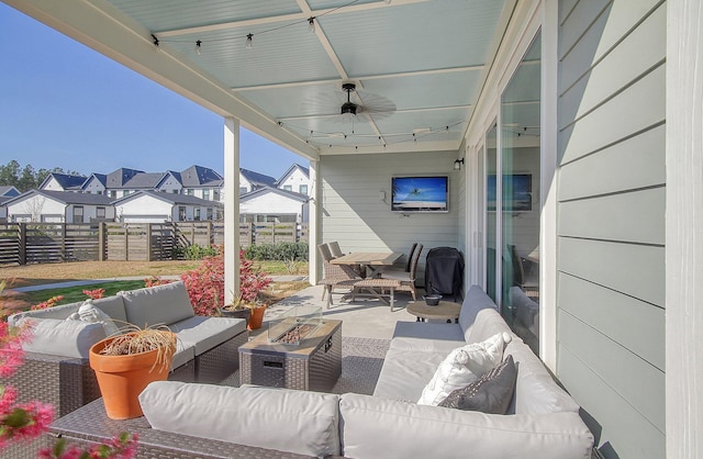 view of patio featuring a residential view, an outdoor living space with a fire pit, ceiling fan, and fence