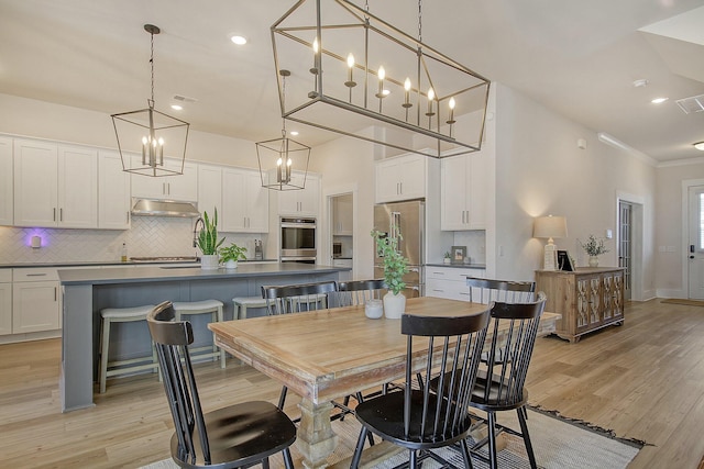 dining area featuring visible vents, recessed lighting, light wood-style floors, and ornamental molding