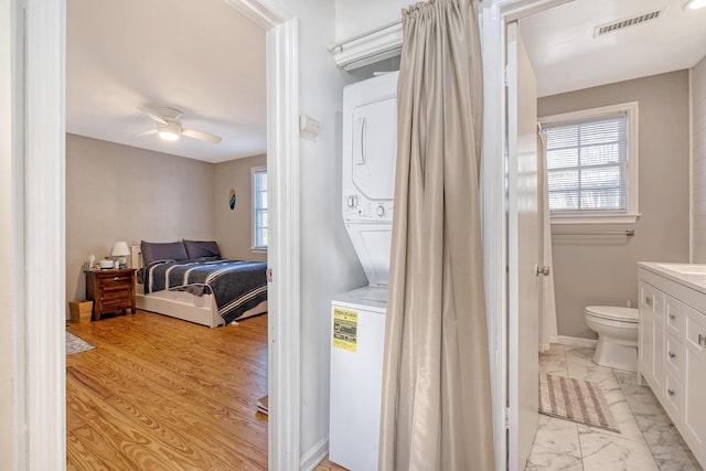 bedroom with connected bathroom, ceiling fan, and light hardwood / wood-style floors