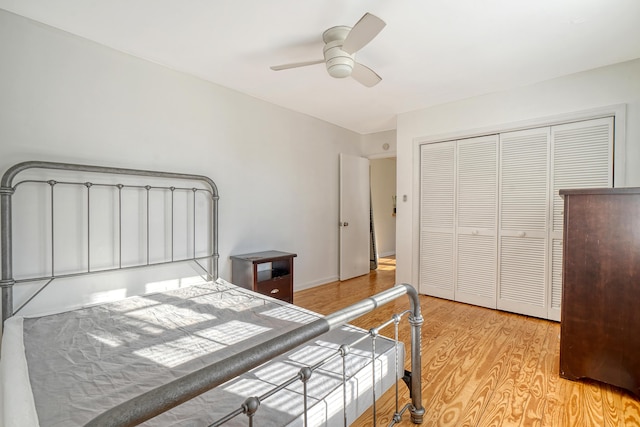 bedroom featuring ceiling fan, light wood-type flooring, and a closet