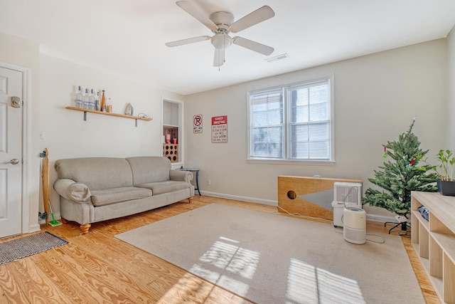 living room with ceiling fan and light hardwood / wood-style flooring