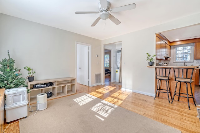 carpeted living room with ceiling fan